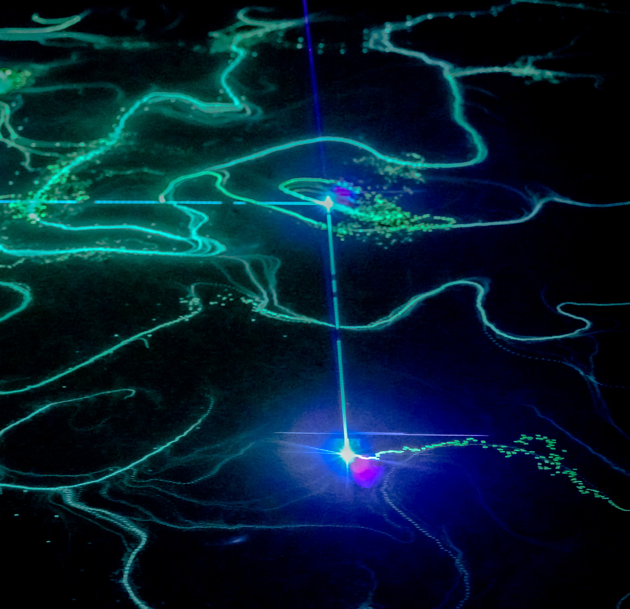 Green light traces mapping fluid contours across a dark field